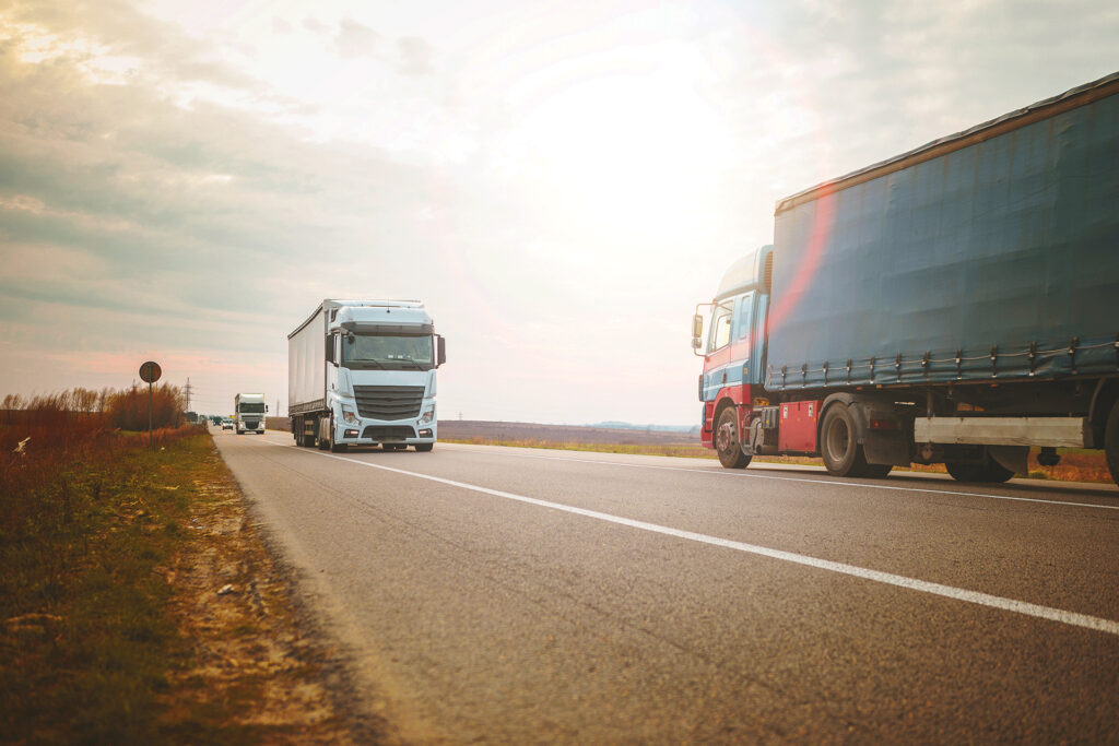 Commercial trucks passing each other on a country road, reflecting the exchange of common knowledge and myths like is blood blue.